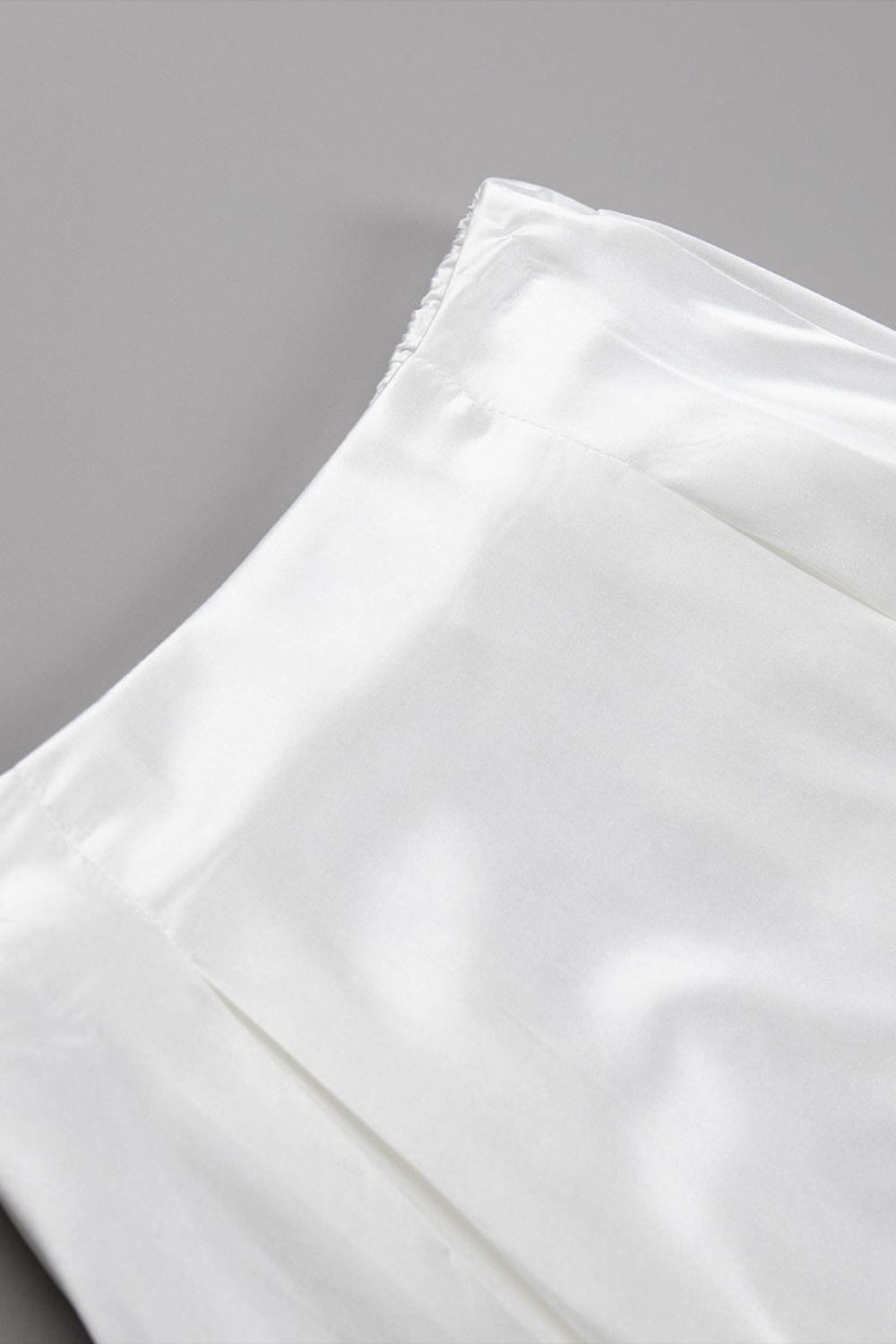 Detail van glanzende champagne satijnen stof maxi rok – luxe damesmode