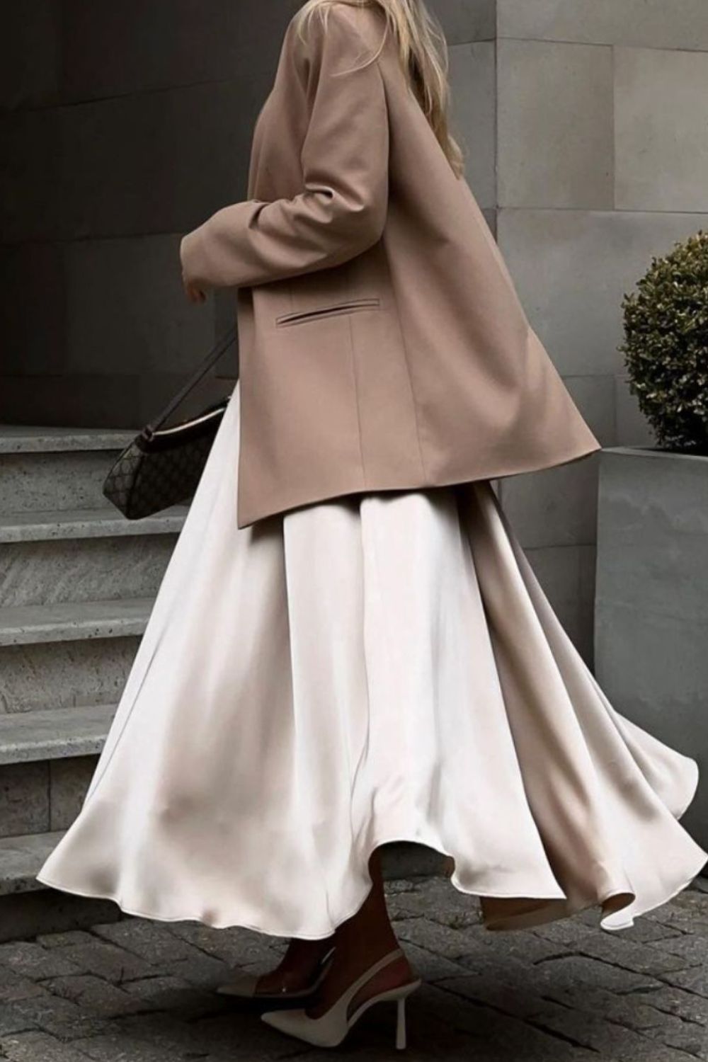 Vrouw draagt champagnekleurige satijnen maxi rok met pumps – elegante dameslook