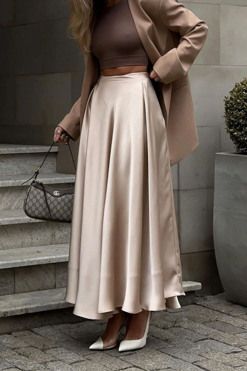 Vrouw draagt champagnekleurige satijnen maxi rok met pumps – elegante dameslook