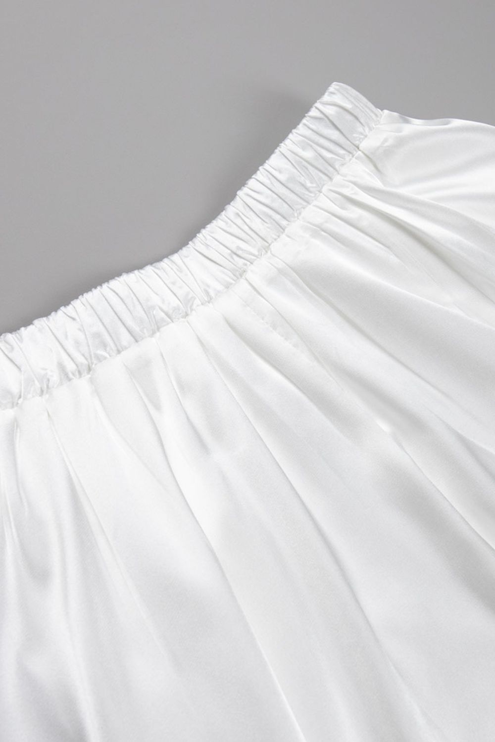Detail van glanzende champagne satijnen stof maxi rok – luxe damesmode