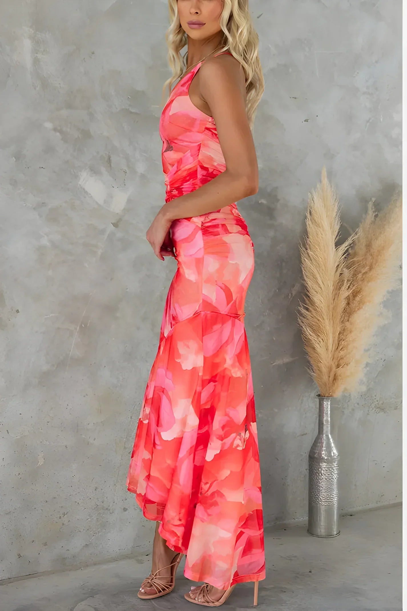 Vrouw draagt de Amara asymmetrische bloemenjurk met oranje bloemenprint