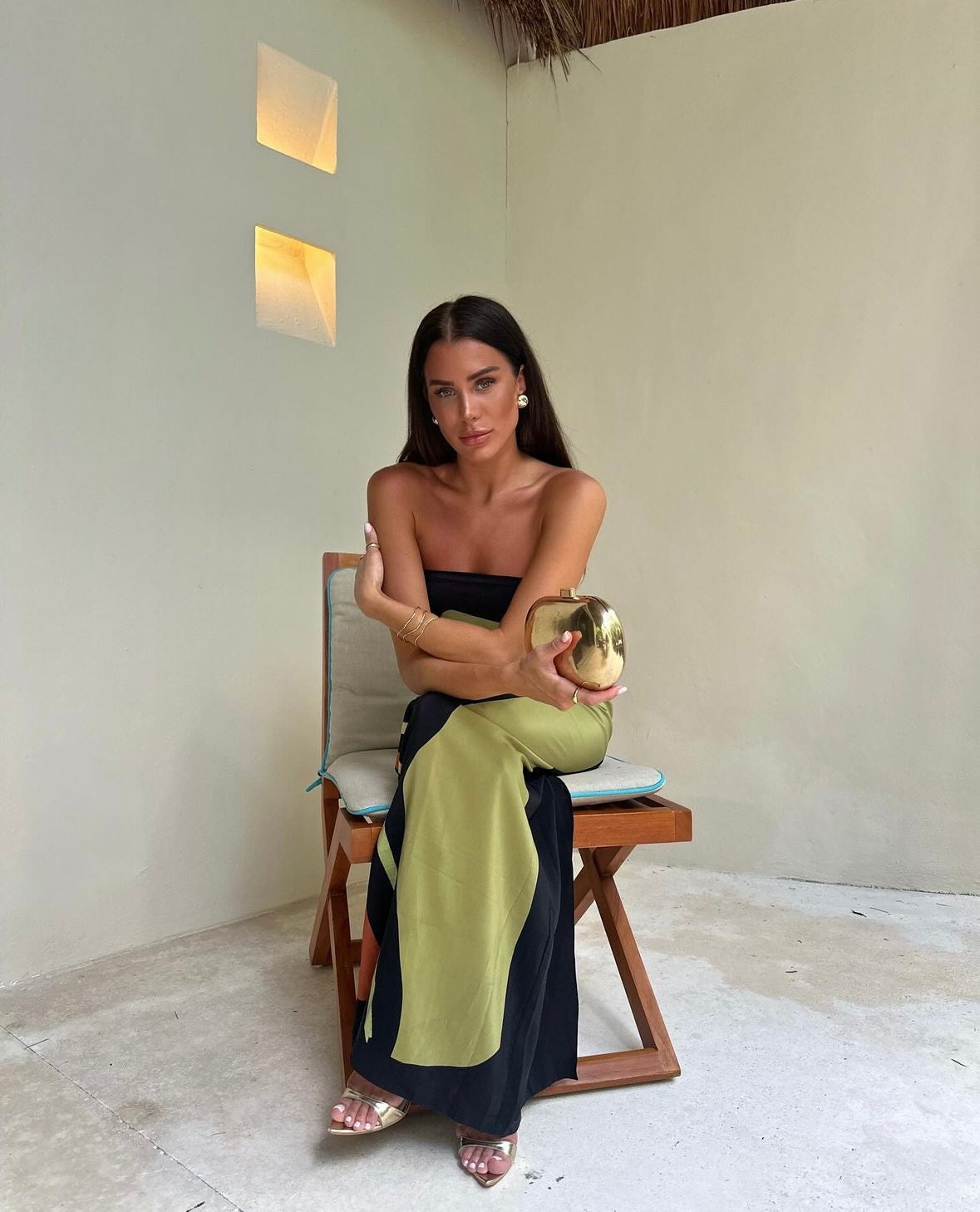 Vrouw draagt de Aria strapless maxi jurk met abstracte print in groen en zwart