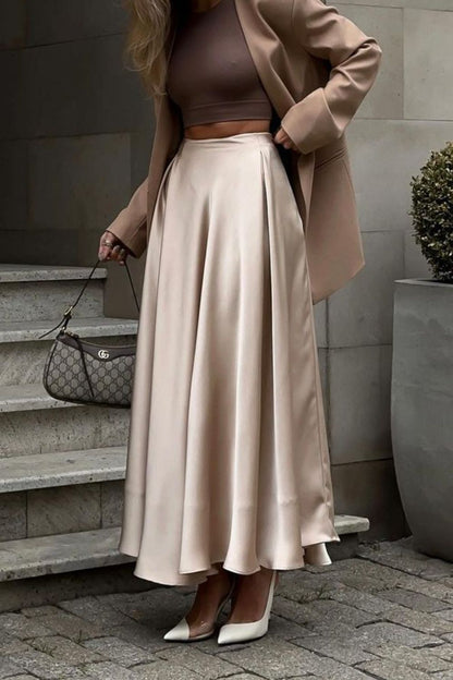 Vrouw draagt champagnekleurige satijnen maxi rok met pumps – elegante dameslook