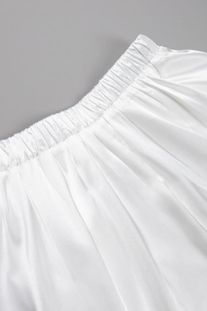 Detail van glanzende champagne satijnen stof maxi rok – luxe damesmode