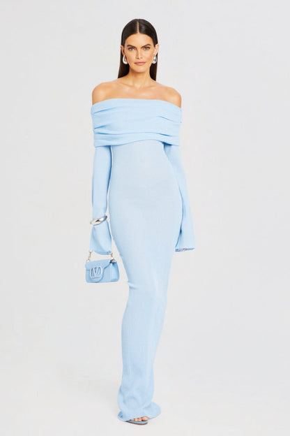 Vrouw draagt de Marina off-shoulder maxi jurk in blauwe kleur met lange mouwen