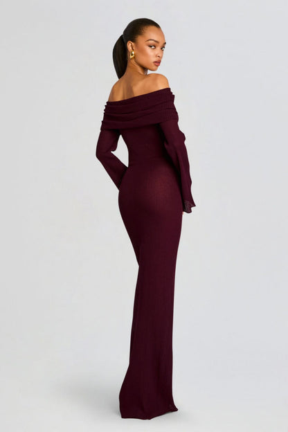 Vrouw draagt de Marina off-shoulder maxi jurk in rode kleur met lange mouwen