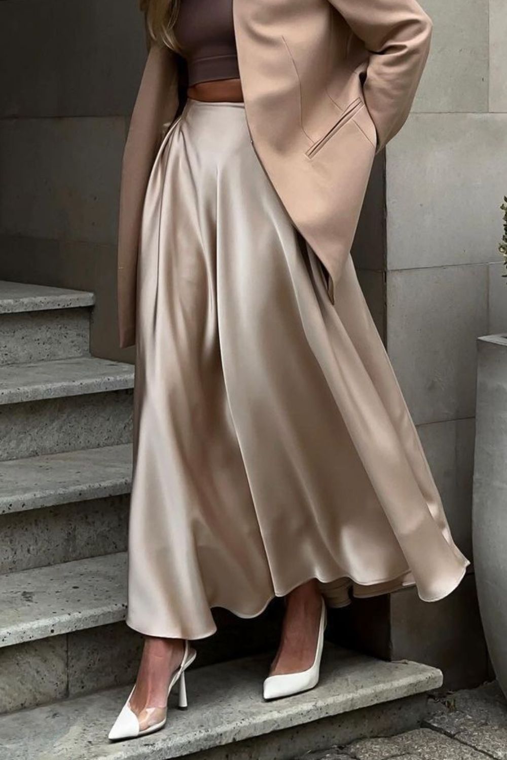 Vrouw draagt champagnekleurige satijnen maxi rok met pumps – elegante dameslook