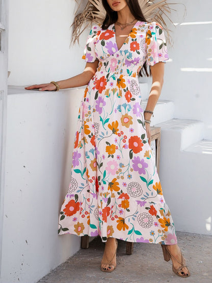 Kleurrijke maxi jurk met bloemenprint, V-hals en korte vlindermouwen – ideaal voor tuinfeesten, vakanties en bruiloften als gast.